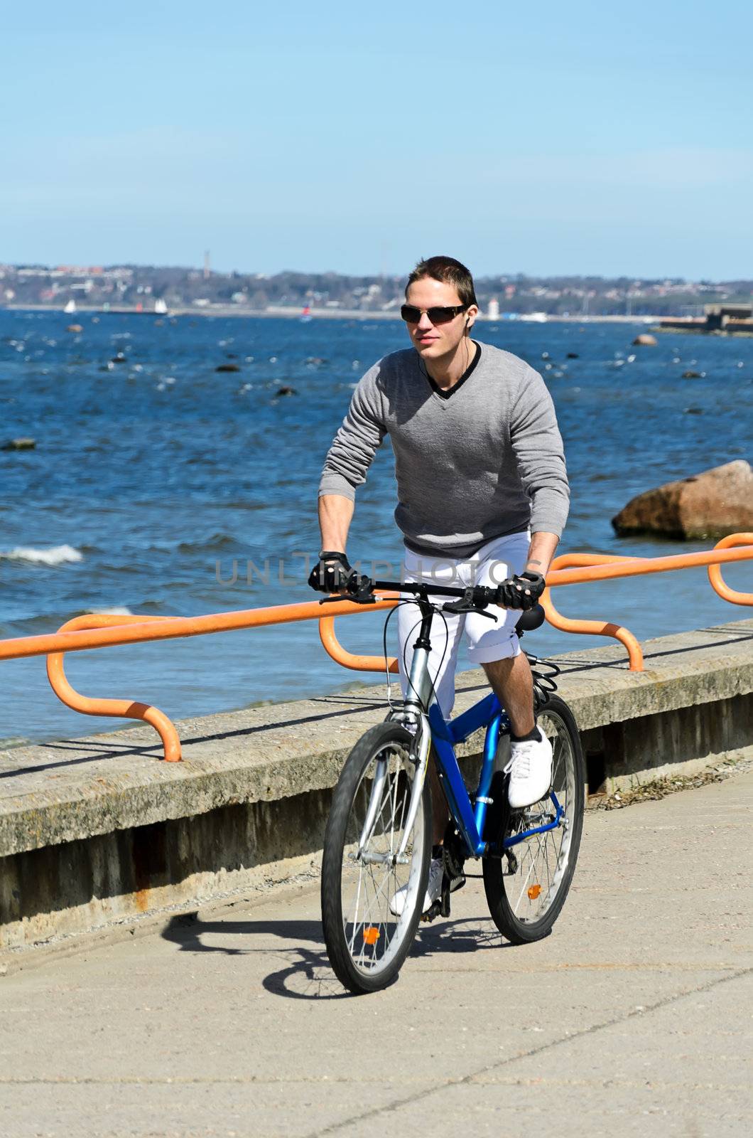 Portrait of handsome male riding a bicycle by the sea
