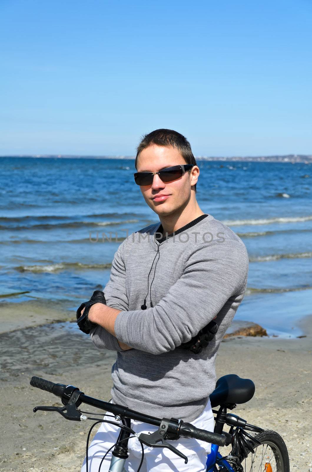 Portrait of handsome male with bicycle by the sea
