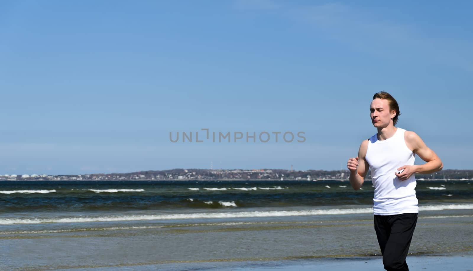 Athletic young male running on the beach