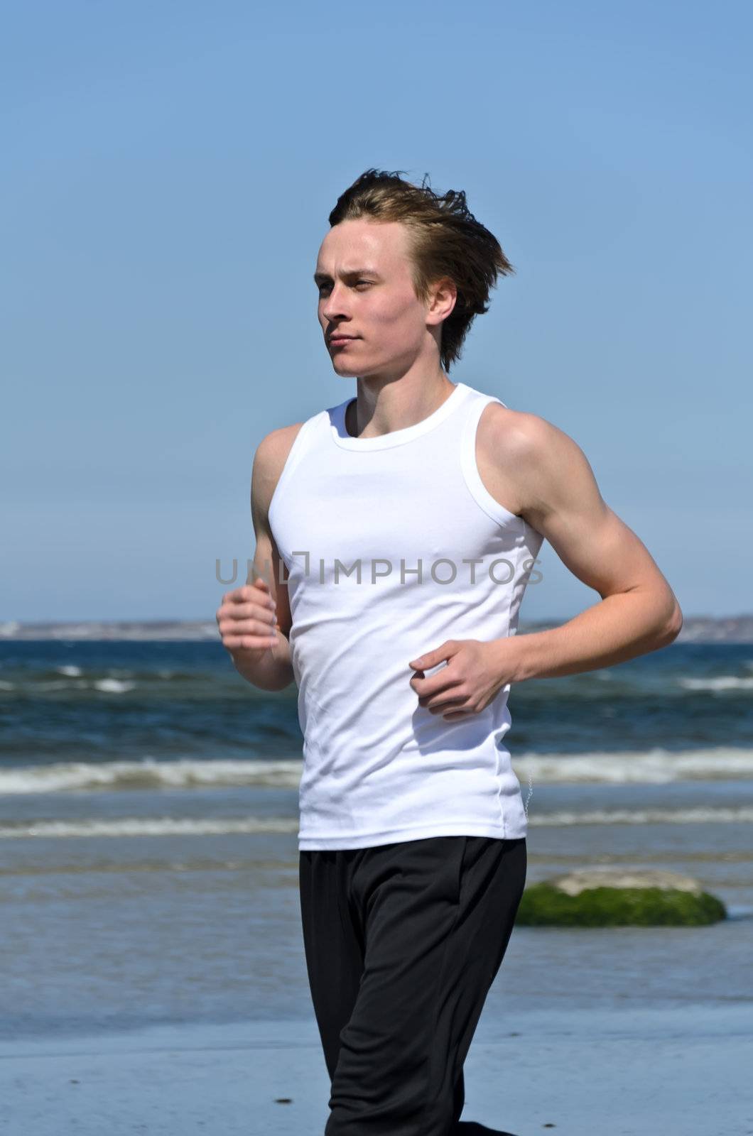 Athletic young male running on the beach