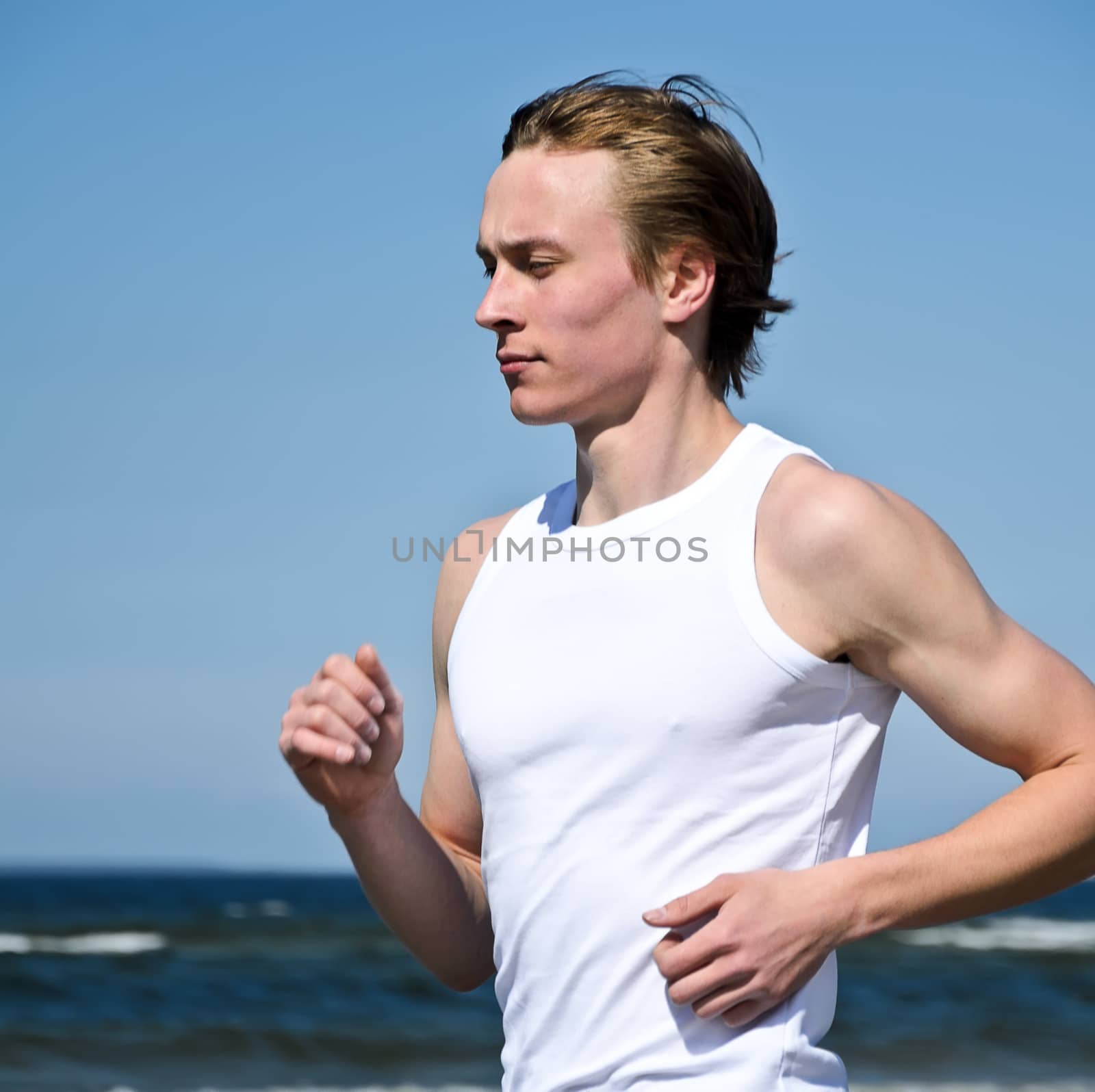 Athletic young male running on the beach