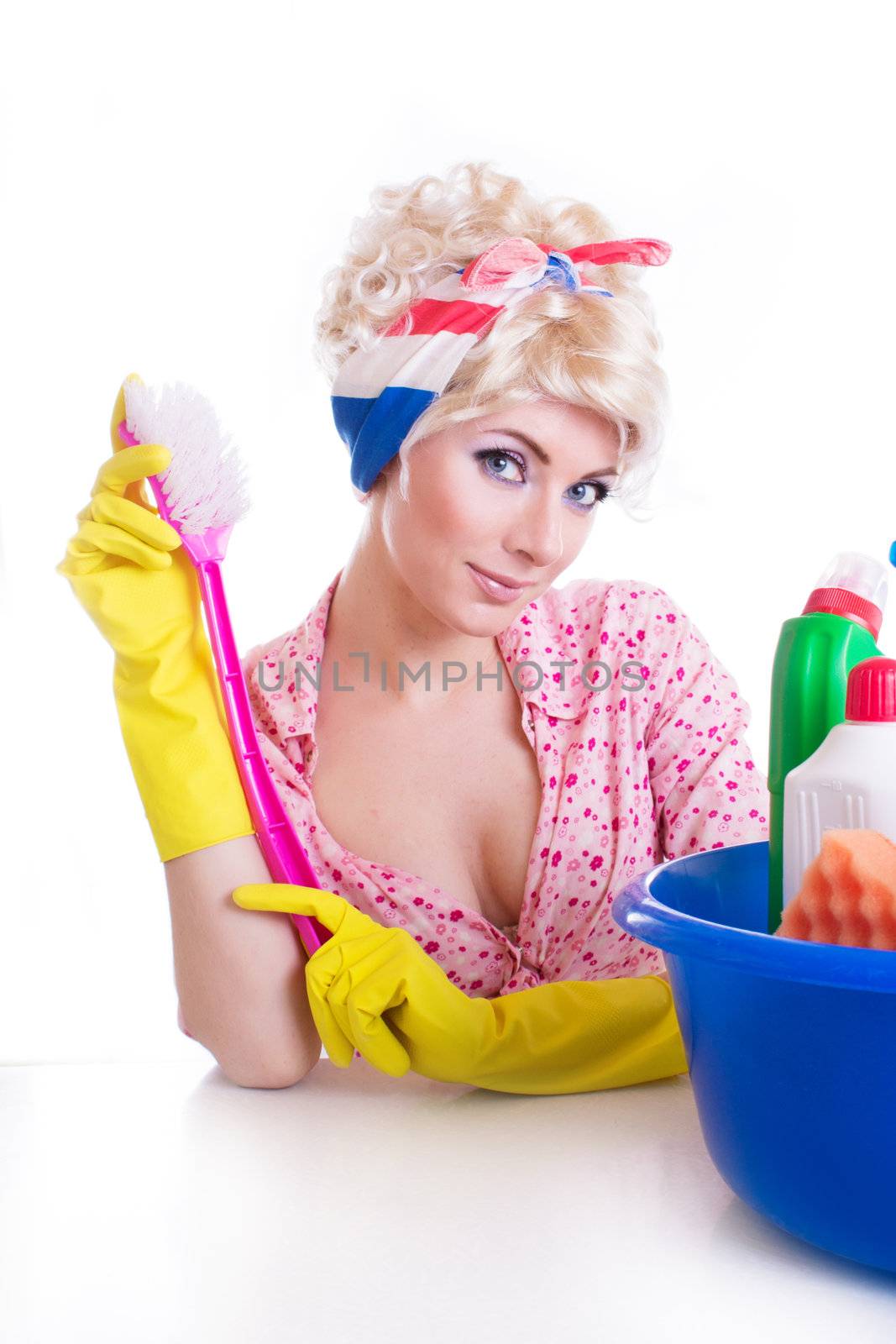 Pinup girl with cleaning brush and set at table over white