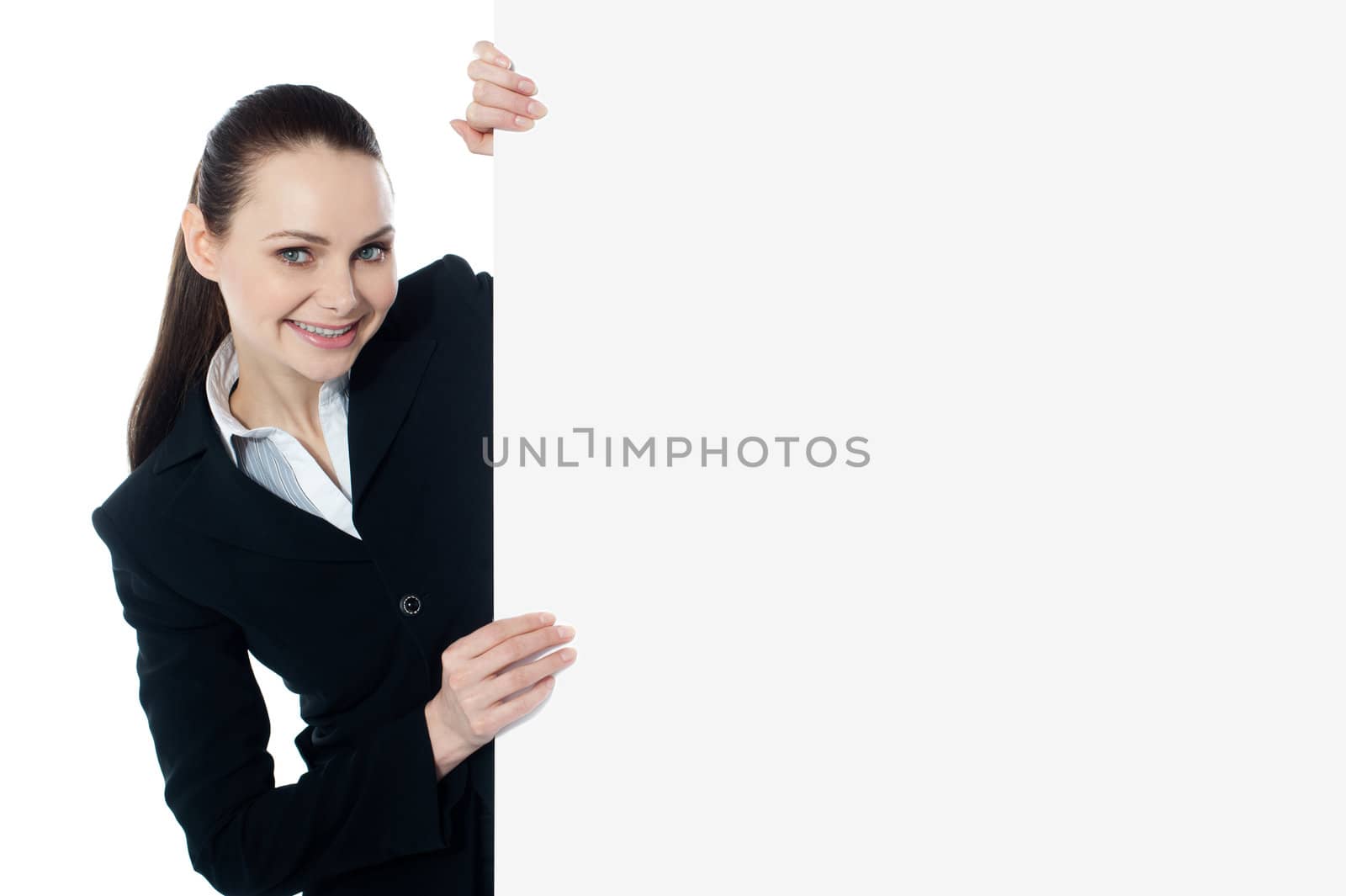 Female executive holding blank whiteboard, smiling at camera