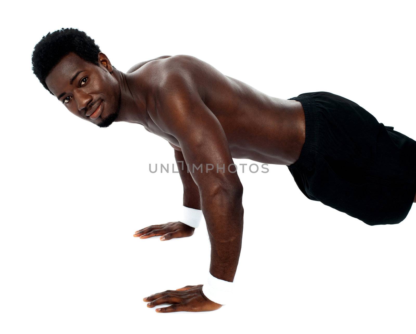 Handsome fit shirtless man doing pushups by stockyimages