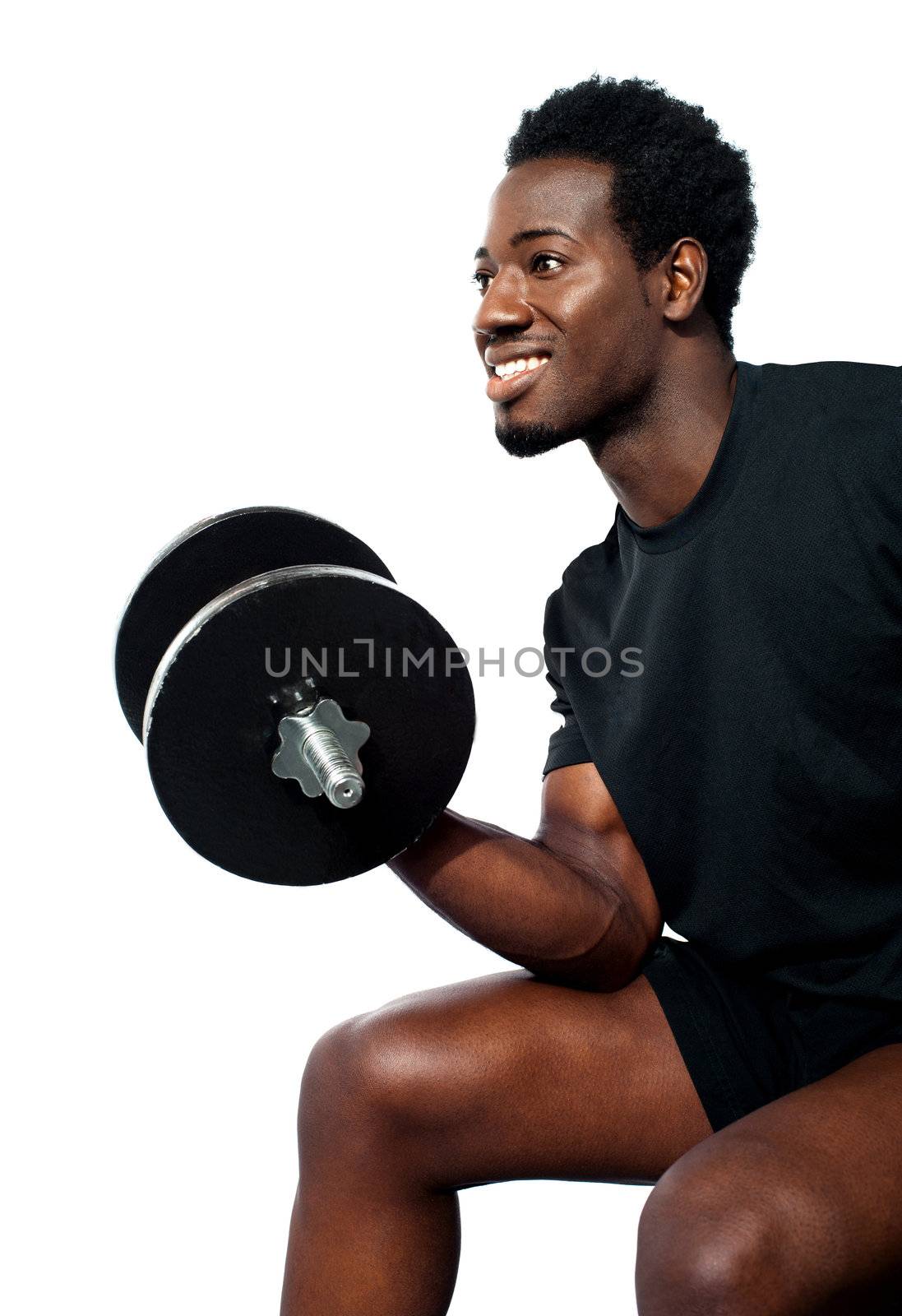 Muscular man in black sportwear with dumbbell, seated