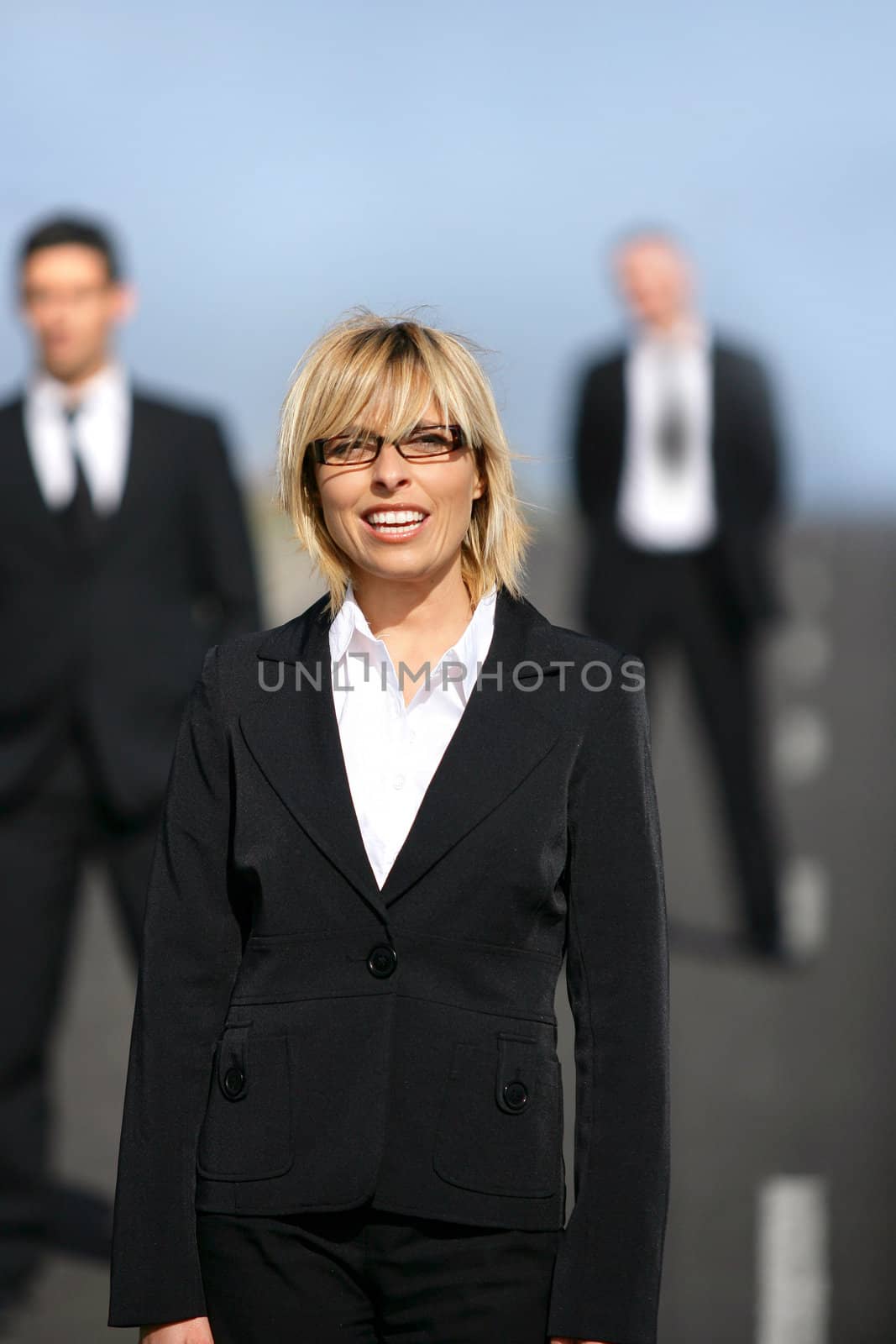 Three businesspeople stood on highway