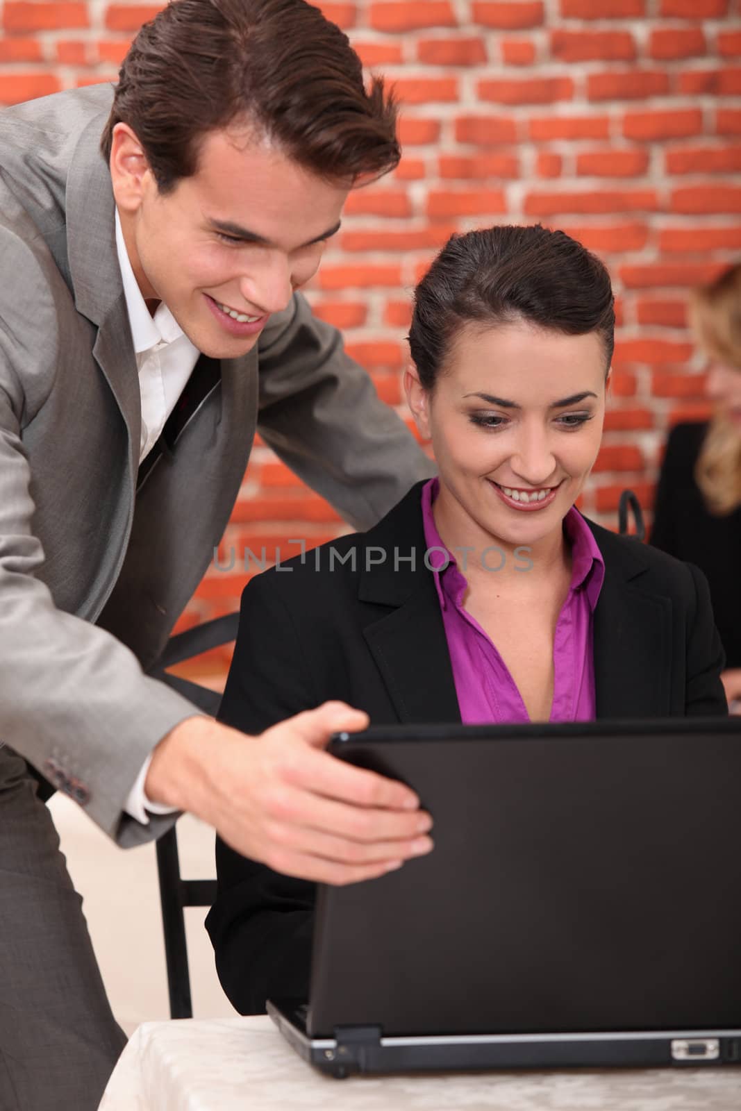 Young businesspeople looking at a laptop