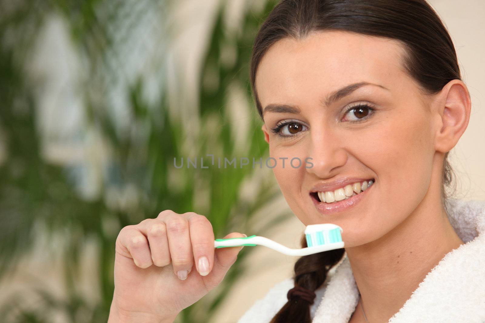 Brown-haired woman brushing teeth