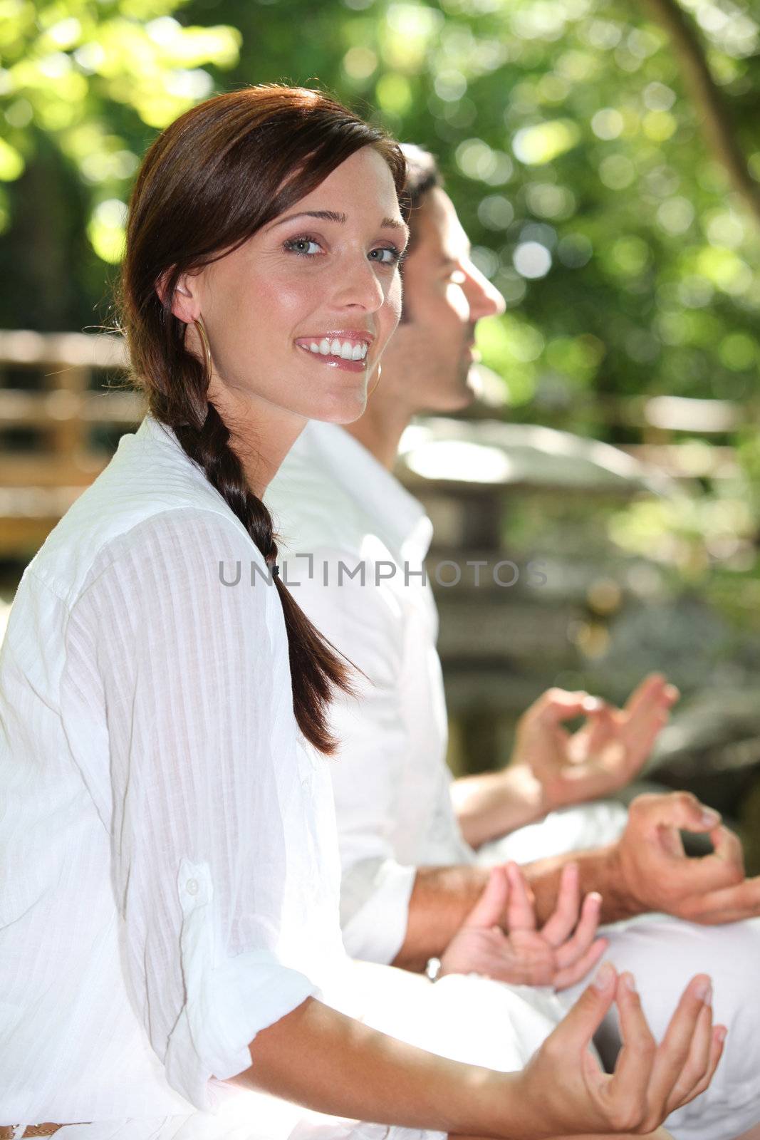 Couple meditating in garden by phovoir