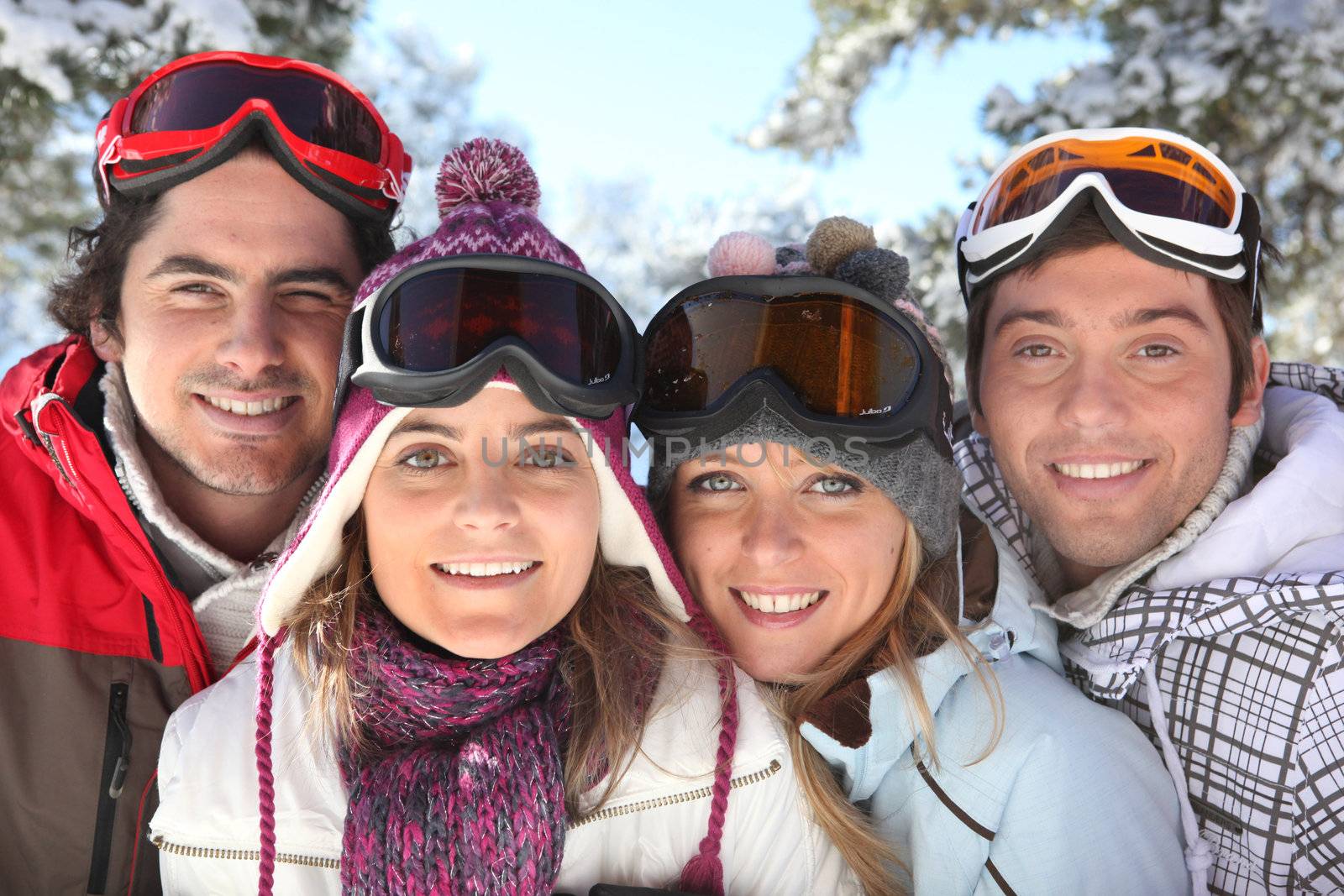 Portrait of a family on a skiing holiday together by phovoir