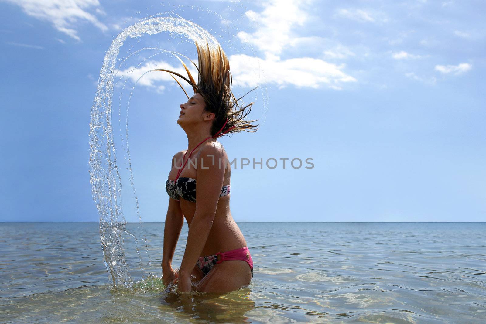Young woman bathing in the sea by phovoir