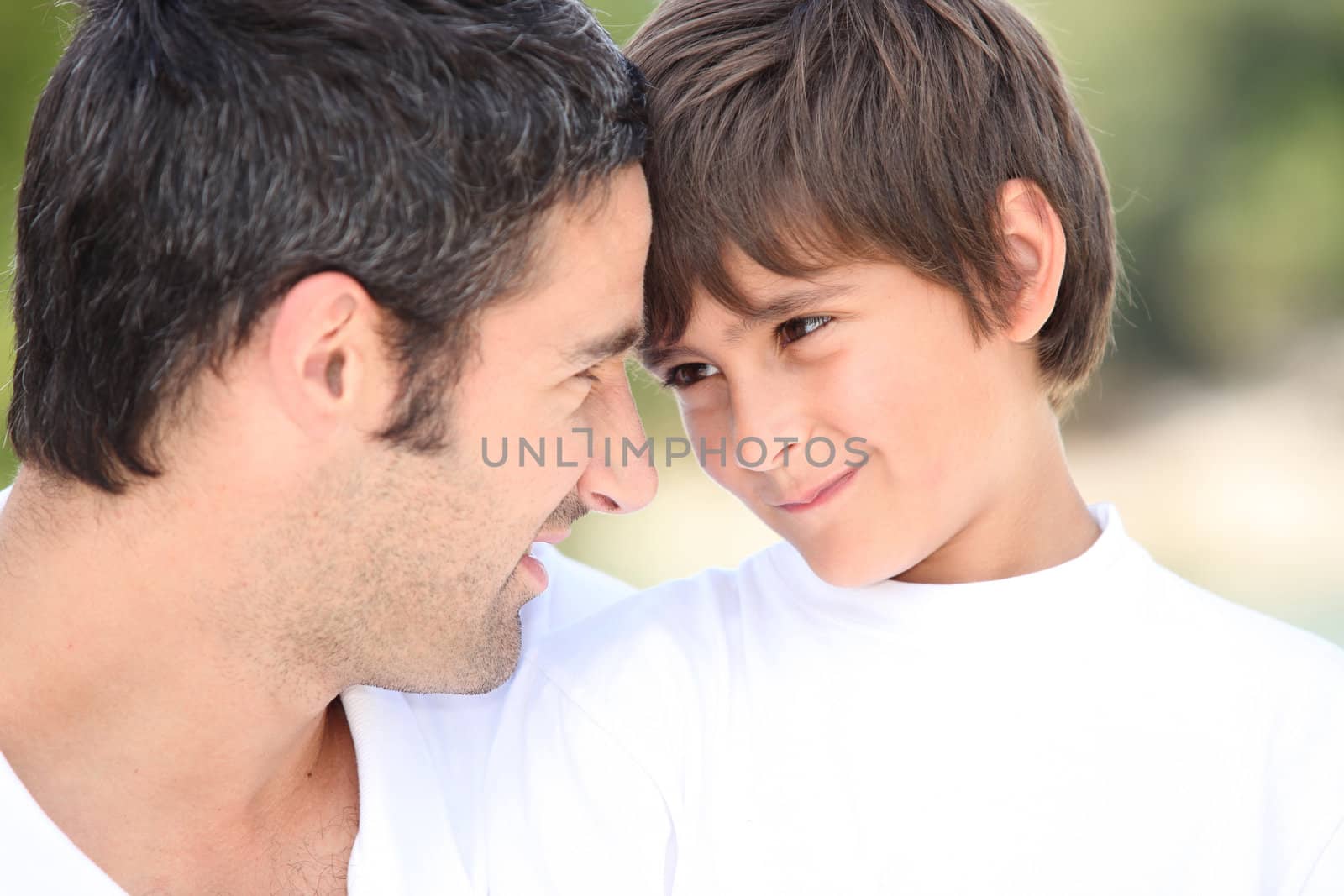 a father and his son looking each other in the eyes by phovoir