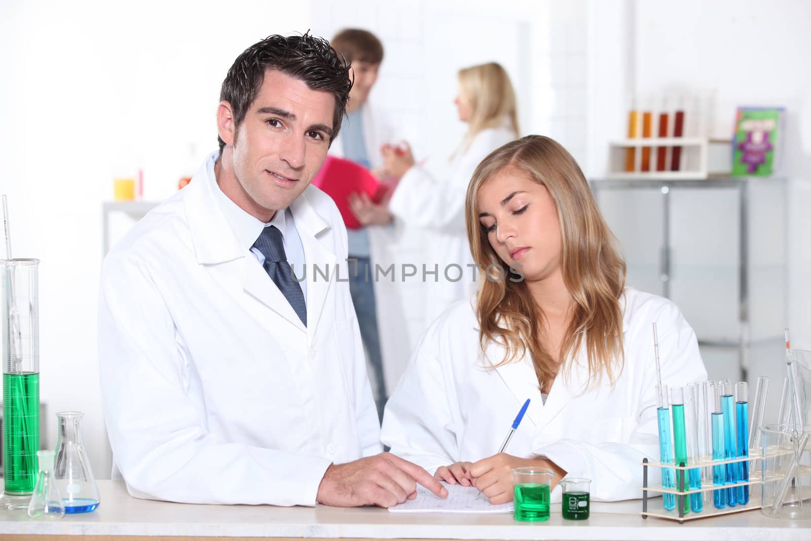 Student and teacher in chemistry class by phovoir