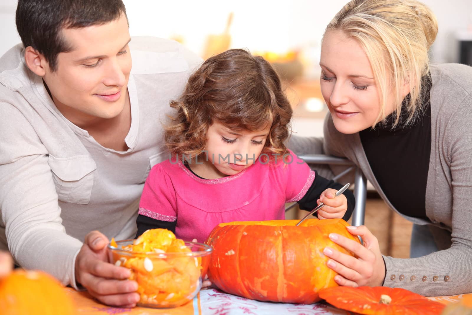 Family carving a pumpkin by phovoir