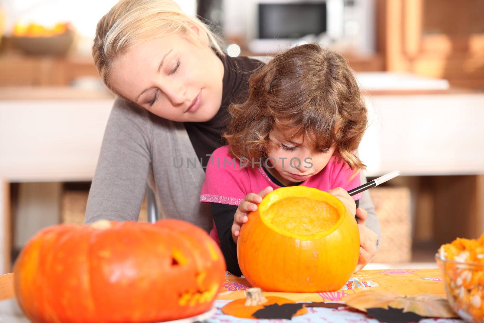 Mother and daughter preparing pumpkin in kitchen by phovoir