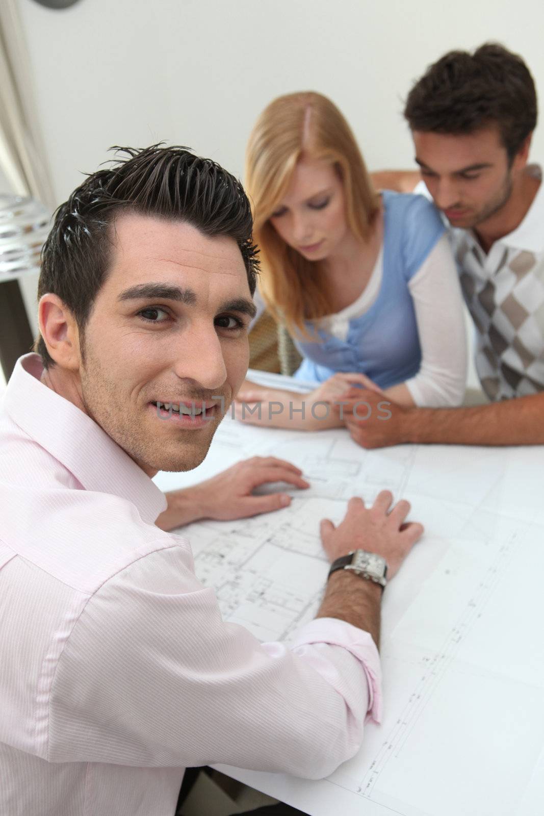 Couple looking at property plans by phovoir