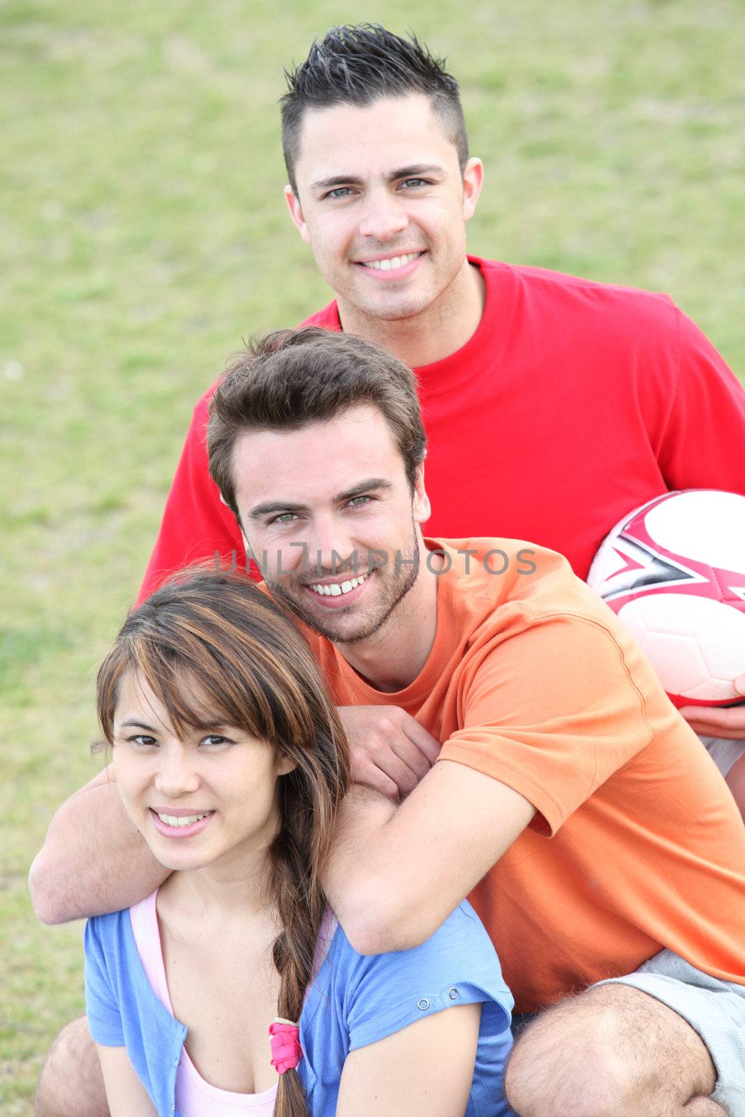 Young people playing soccer in a park by phovoir