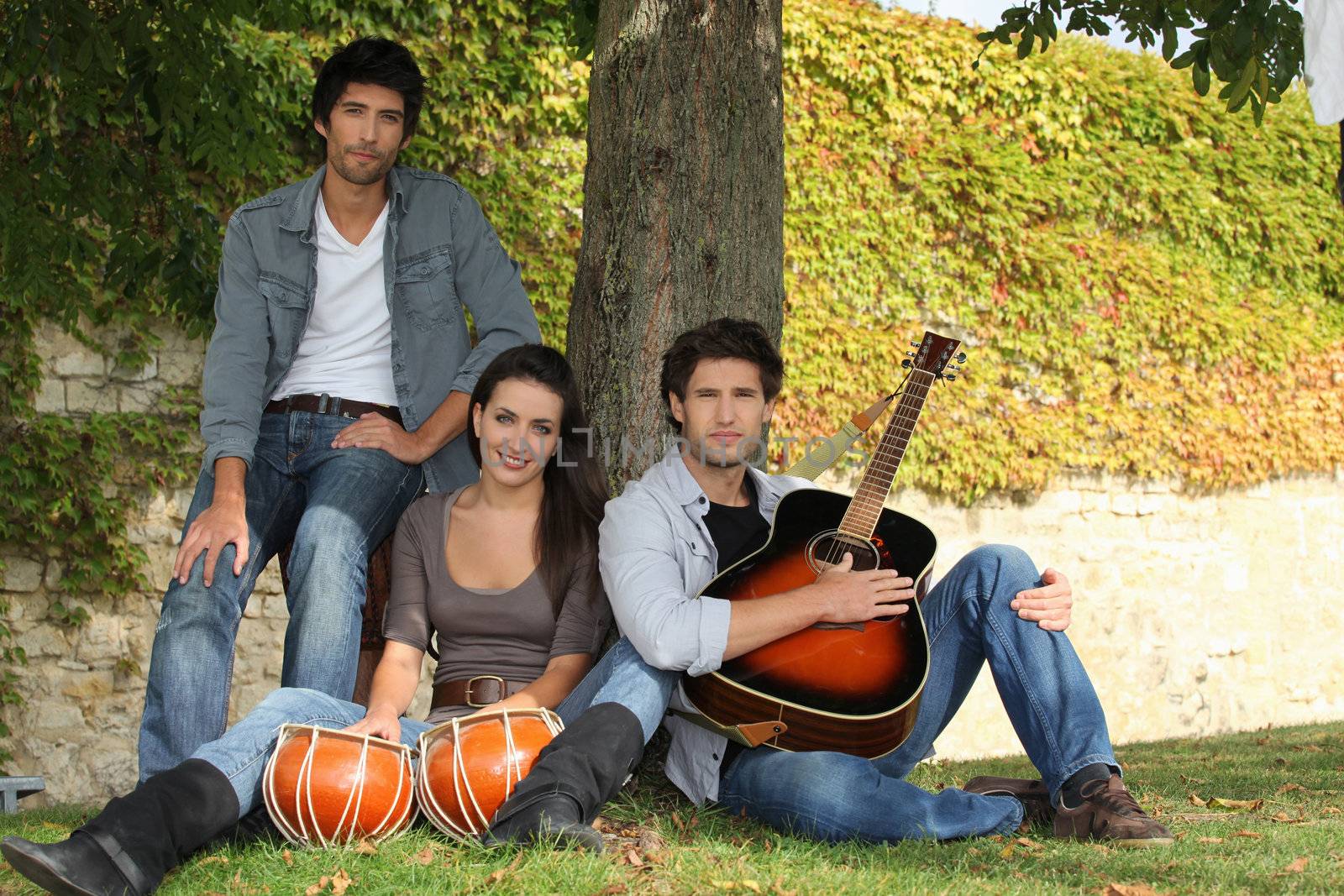 Men and young woman with music instruments outdoors