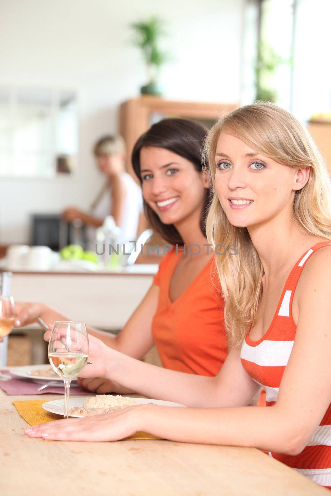 Female housemates eating together by phovoir