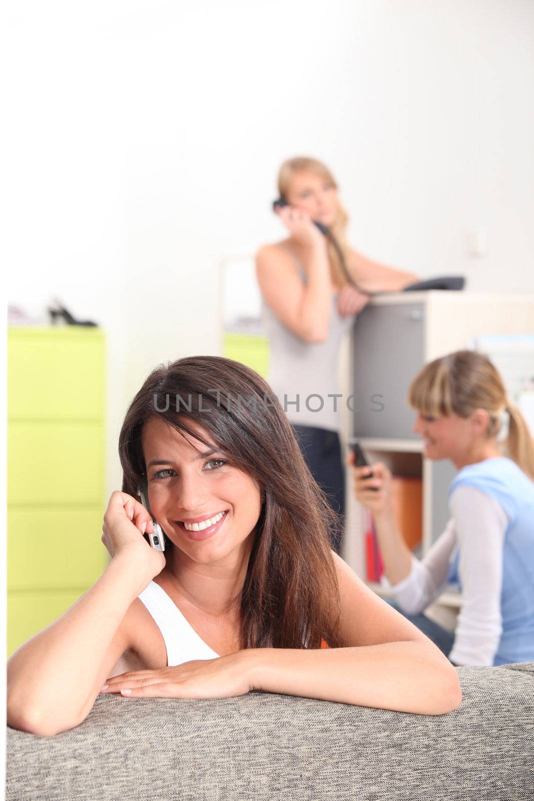 Three flatmates all using a telephone