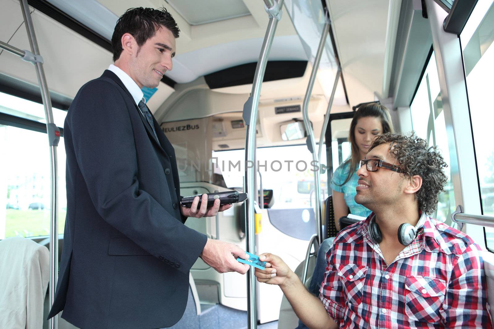 A young controller controlling passengers in a bus. by phovoir