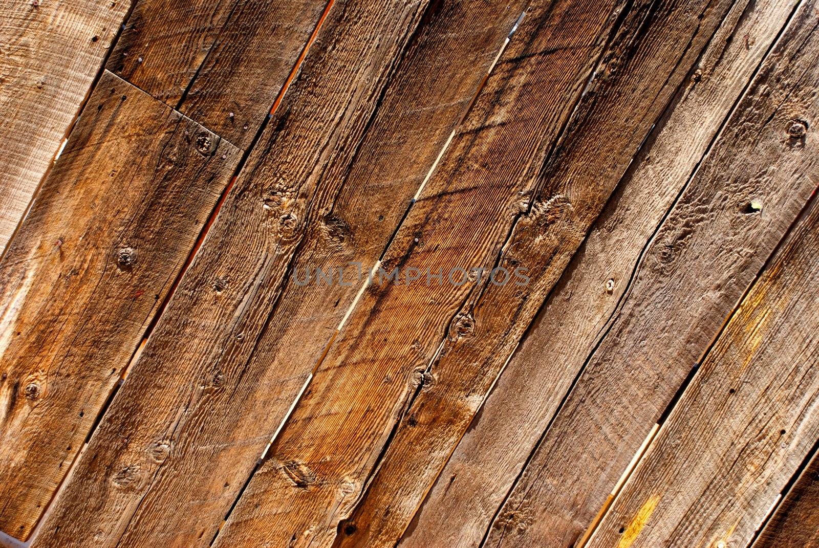 Worn and weathered planks make up a richly grained wooden fence