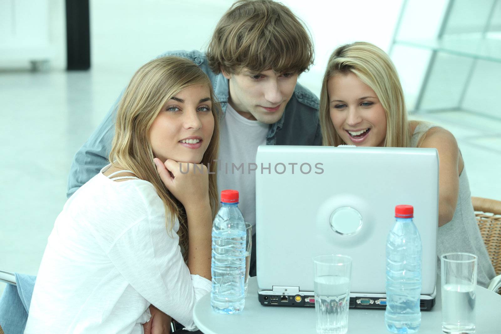 Three teenager sat by computer