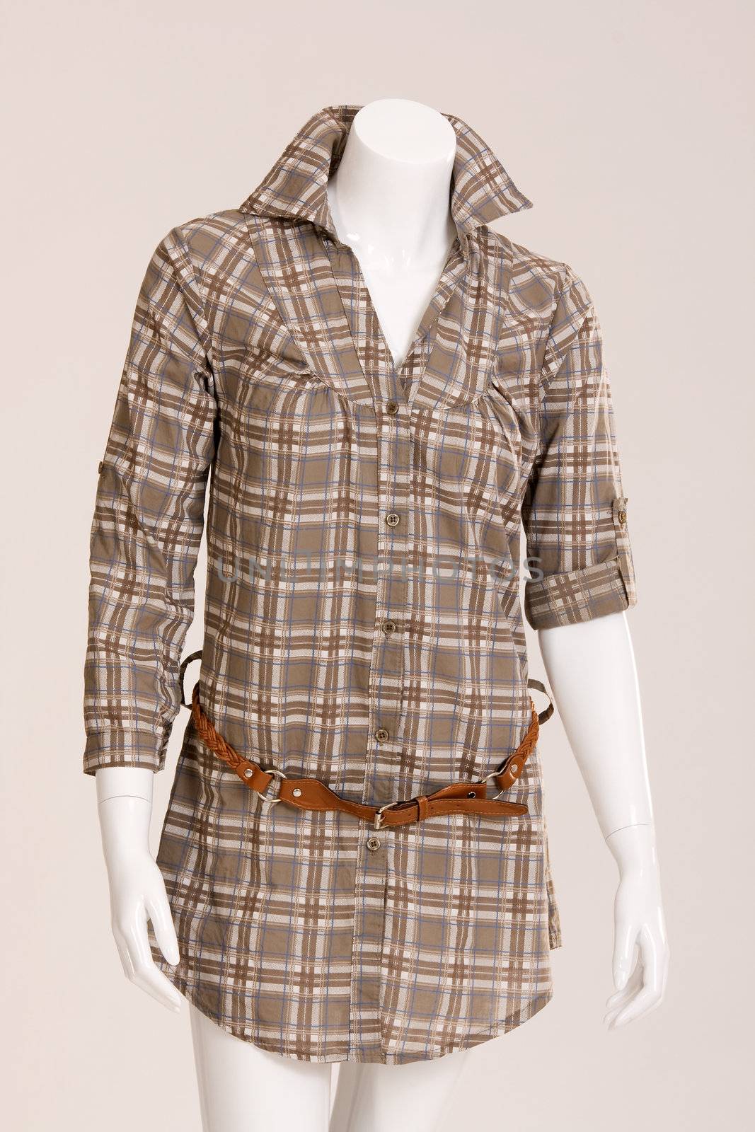 Brown checkered blouse with a brown belt on a mannequin