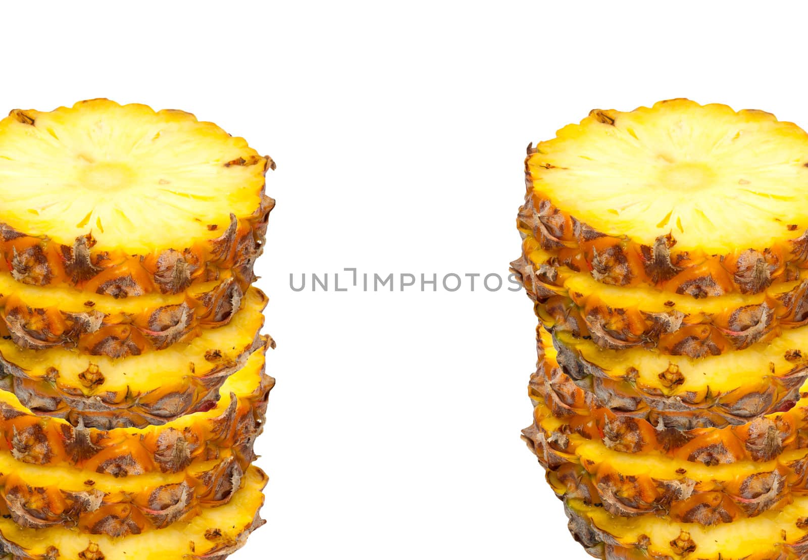 Ripe pineapple fruits slices in pile isolated on white 