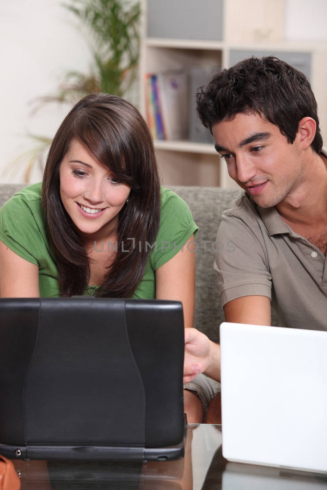 Young couple with their laptop computers by phovoir
