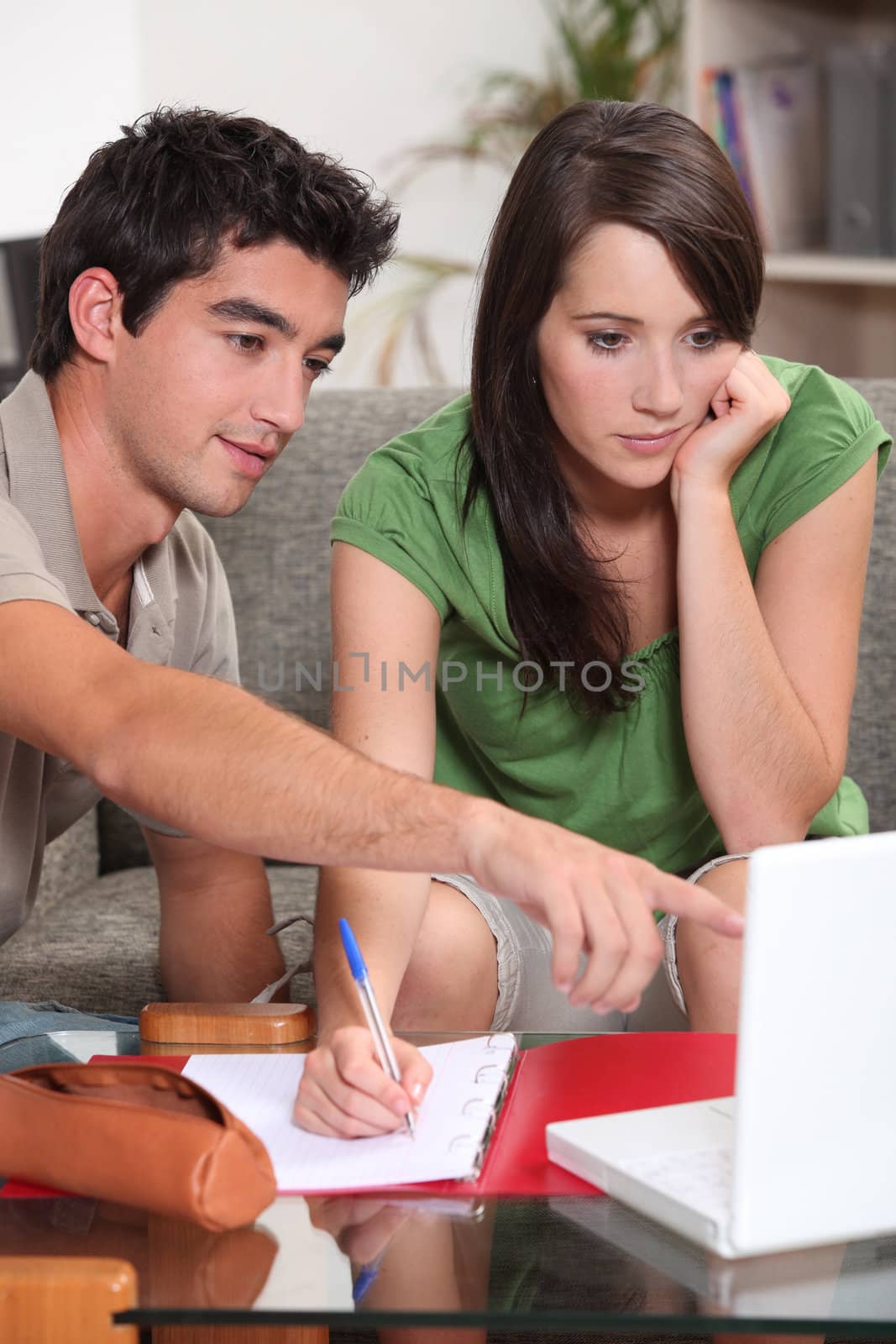 couple looking at laptop and taking notes