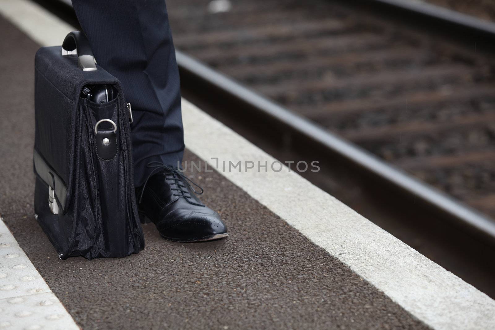 Businessman waiting for the train by phovoir