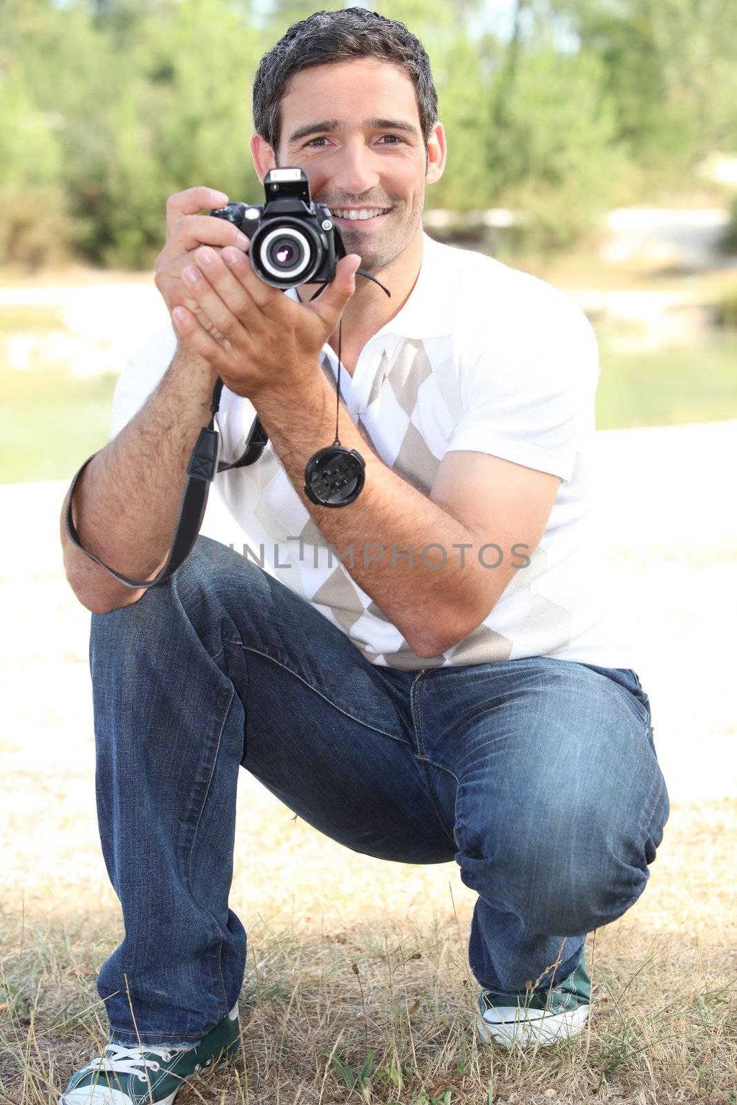 Photographer crouching in the countryside