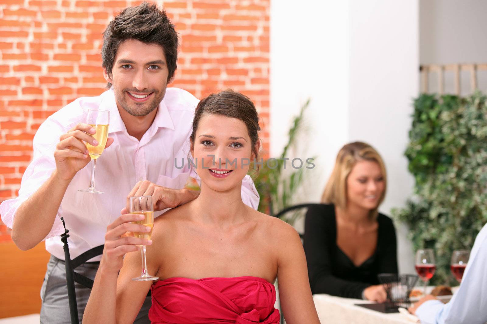 Couple holding champagne flutes in restaurant