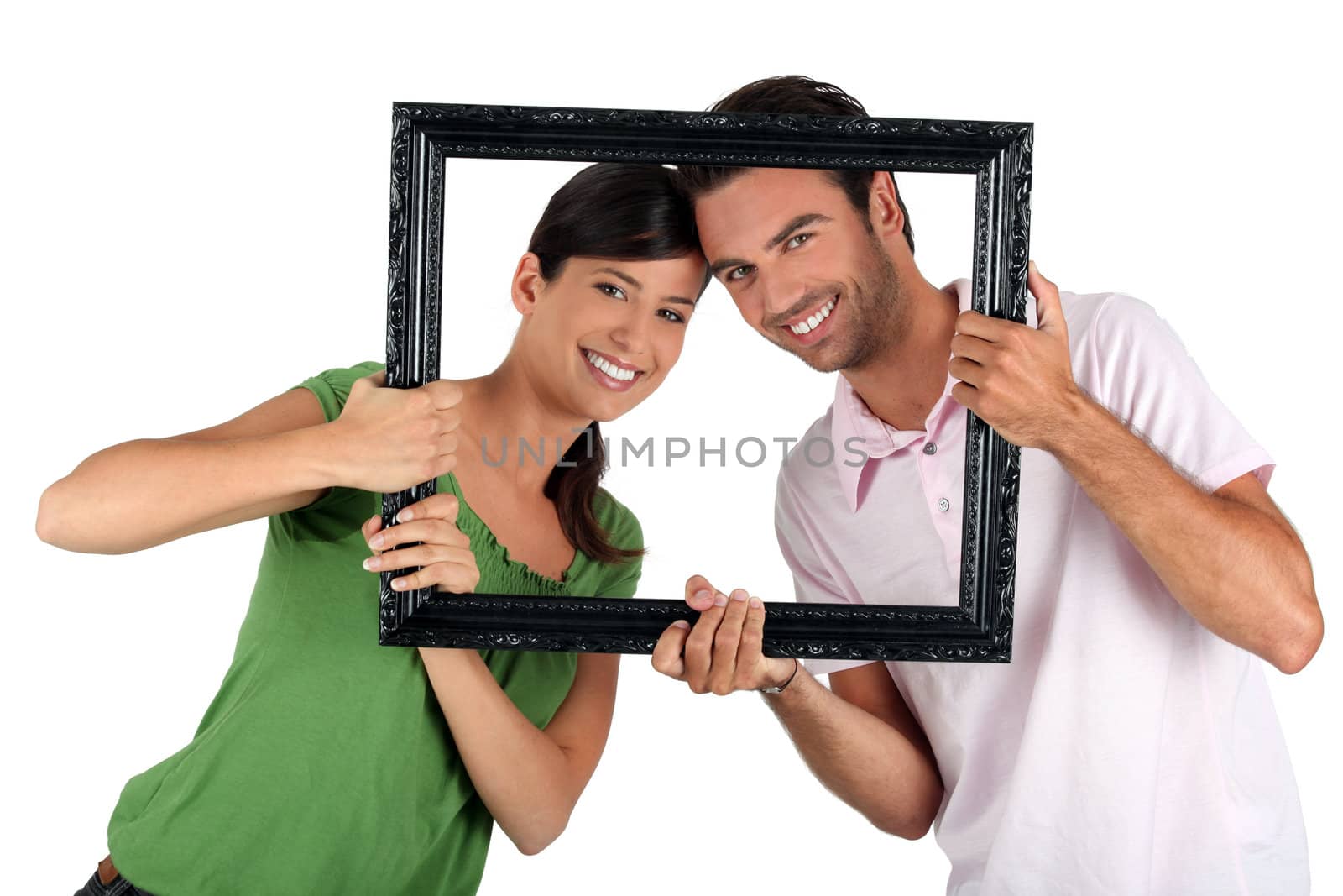 Couple holding empty art frame by phovoir