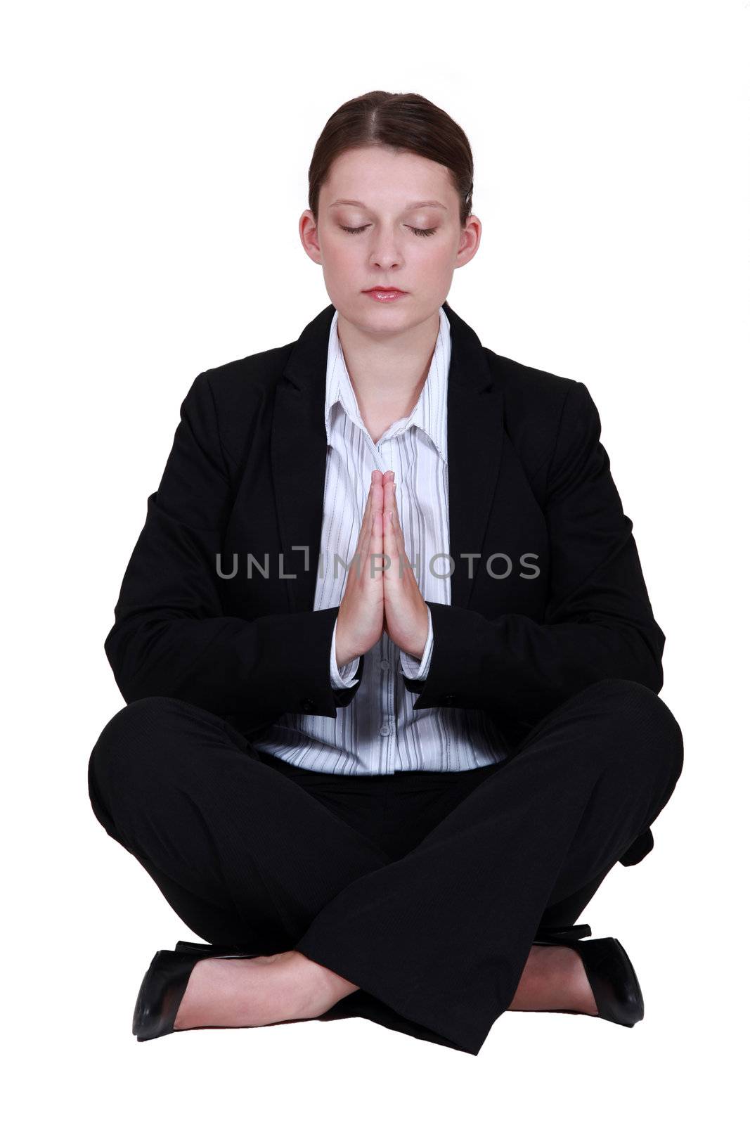 Young businesswoman meditating