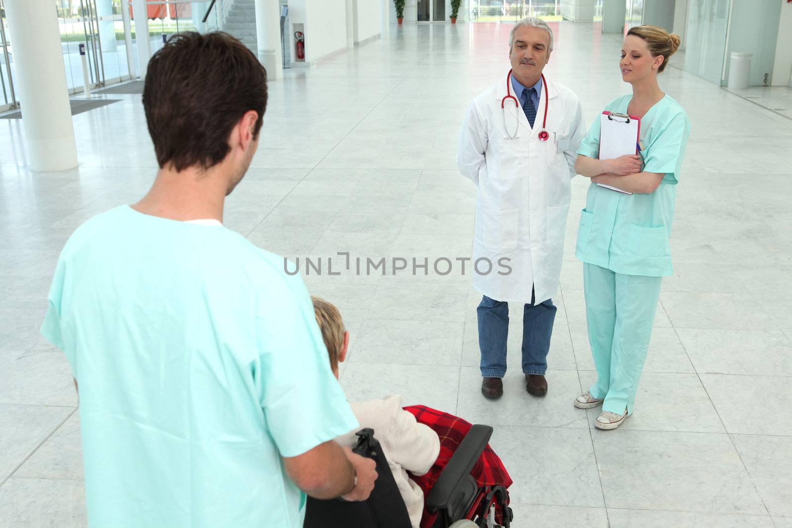 hospital worker taking care of senior patient in a wheelchair