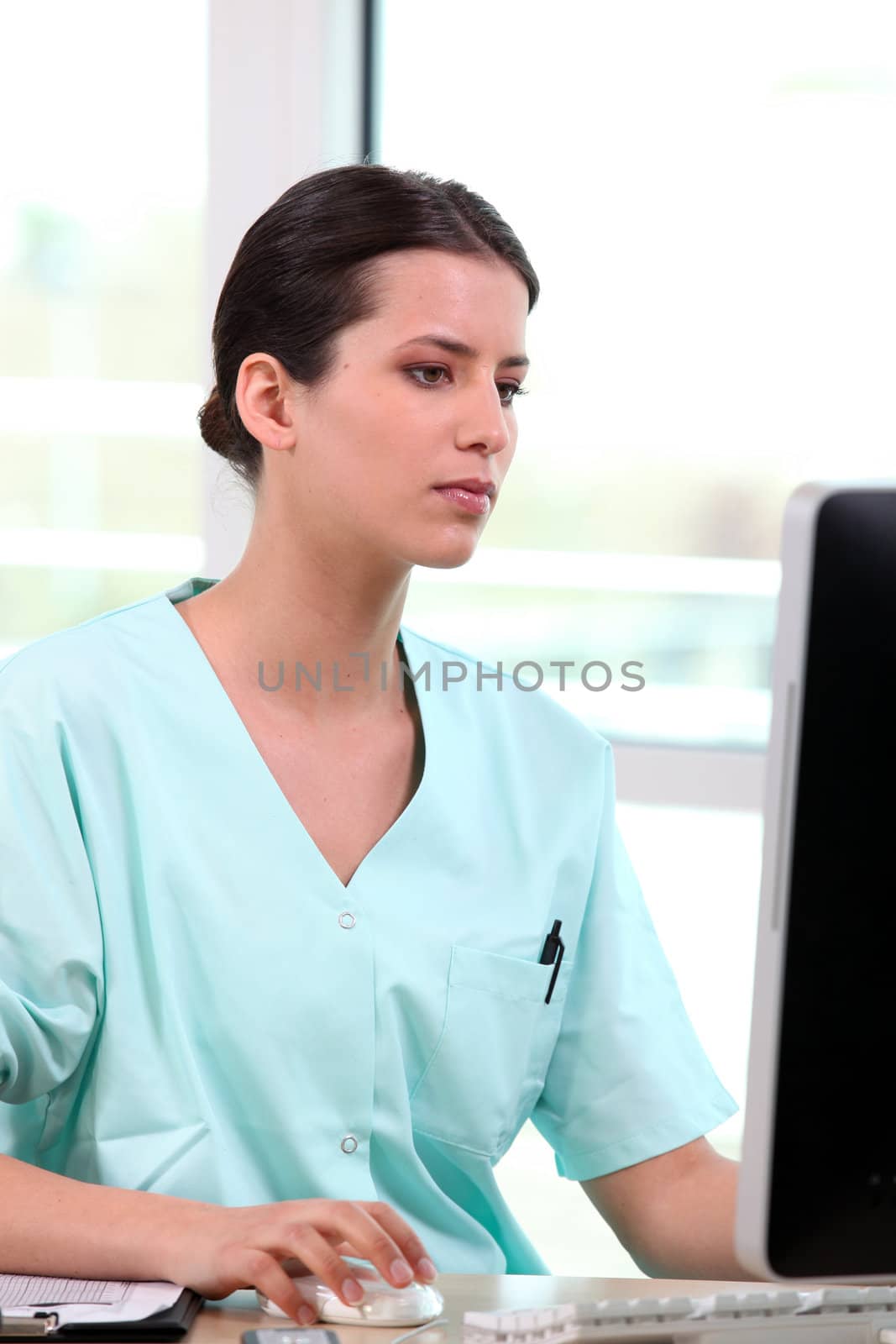 Nurse sitting at a computer by phovoir