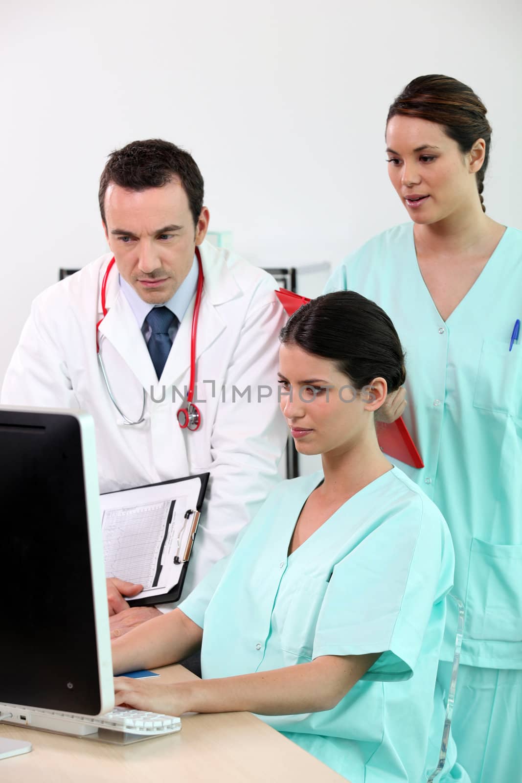 medical staff using computer by phovoir