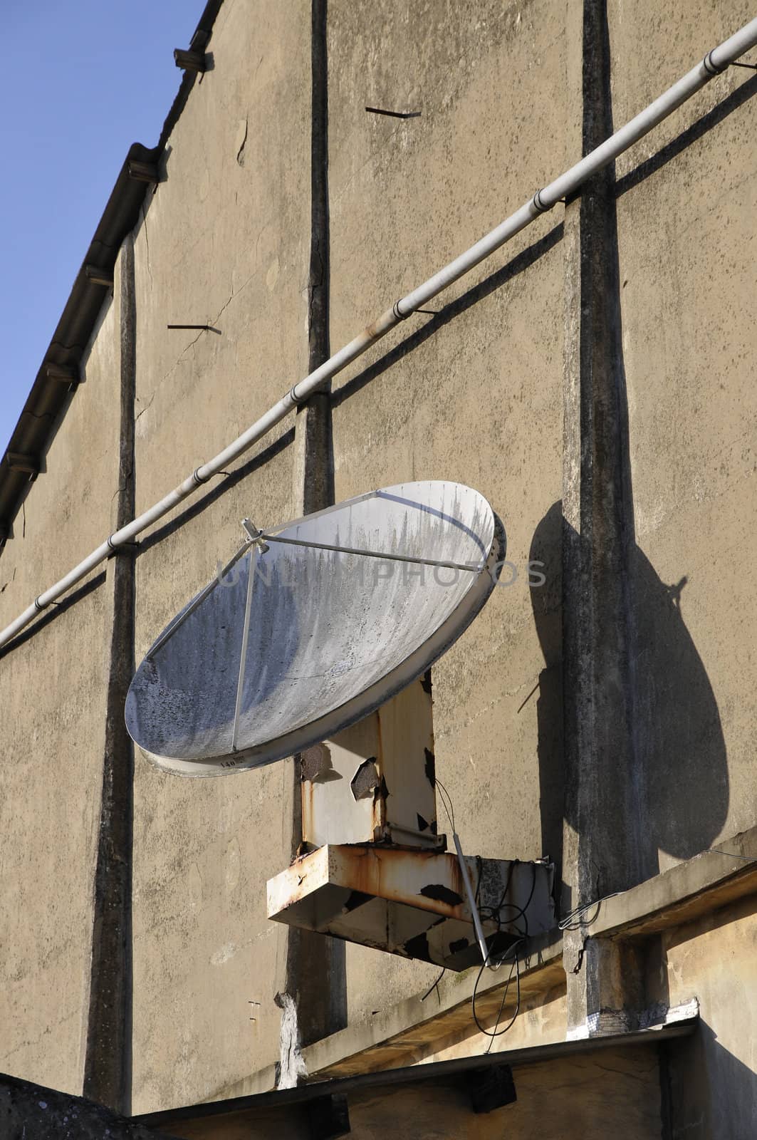 Very old dish antenna on a wall by shkyo30