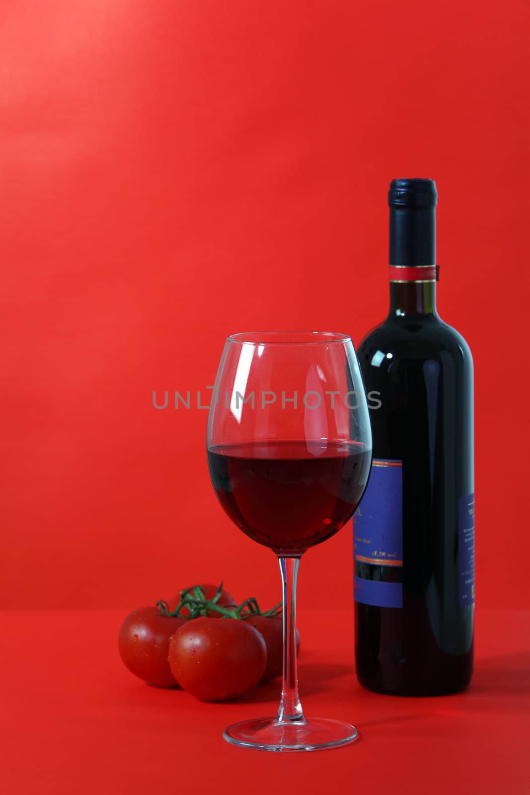 Red wine and glass with red background