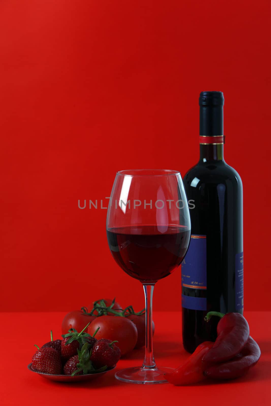 Red wine and glass with red background