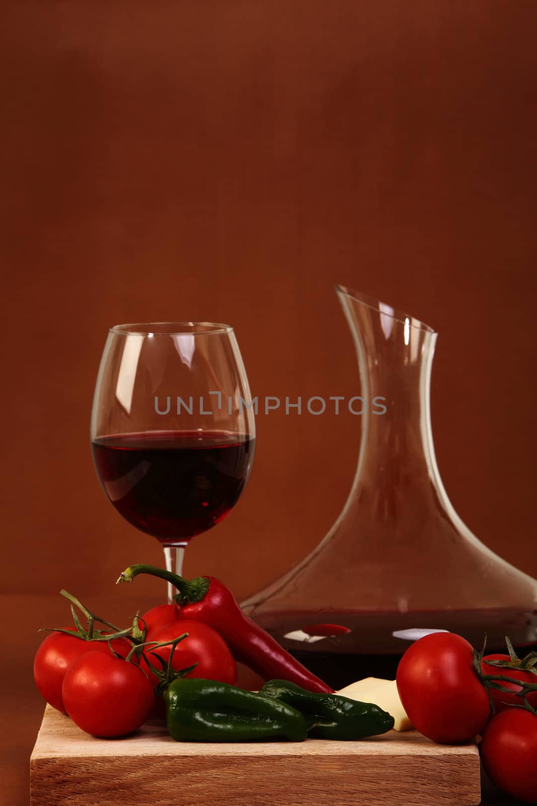 Red wine and glass with red background with vegetales