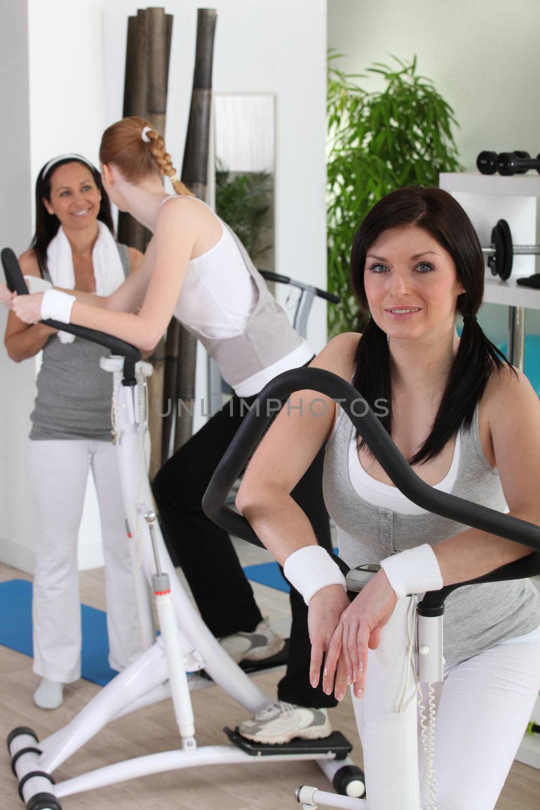 Women using gym equipment by phovoir