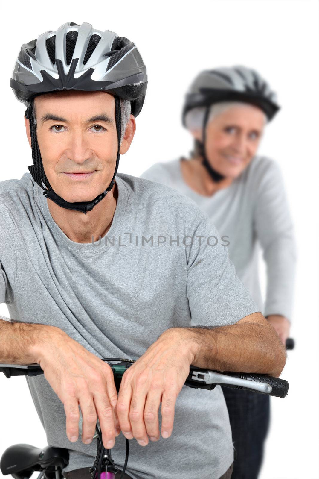 Elderly couple cycling by phovoir