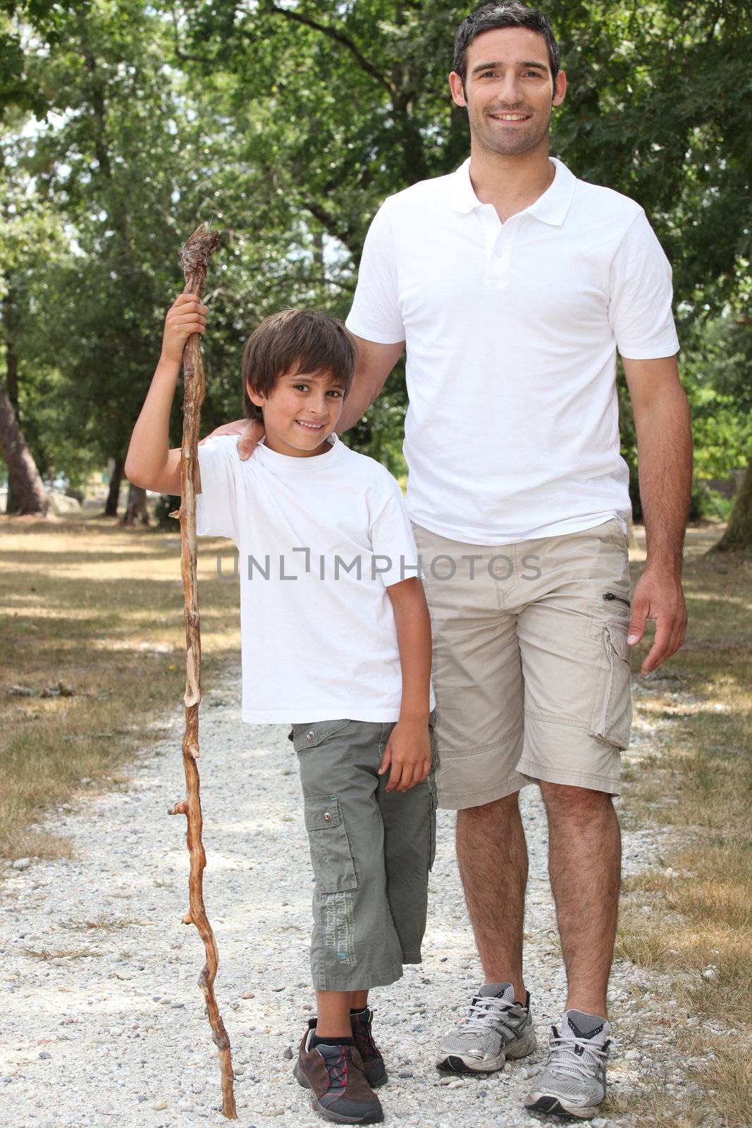 Father and son walking in the countryside by phovoir