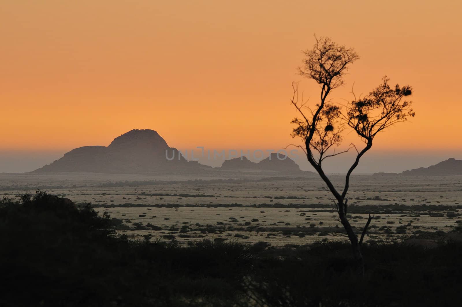 Fog from the Atlantic Ocean rolling in over the Namib desert and the Klein Spitzkuppe at sunset.