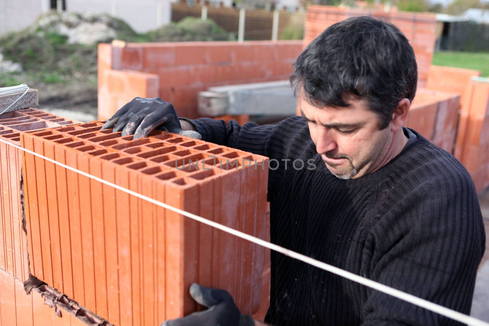 Mason laying bricks by phovoir