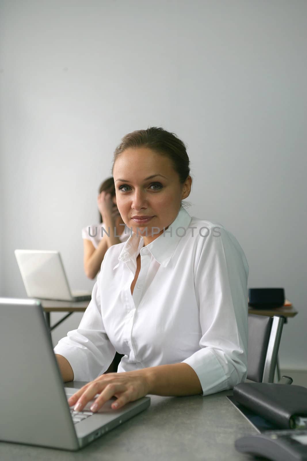 Businesswoman sat at her desk by phovoir