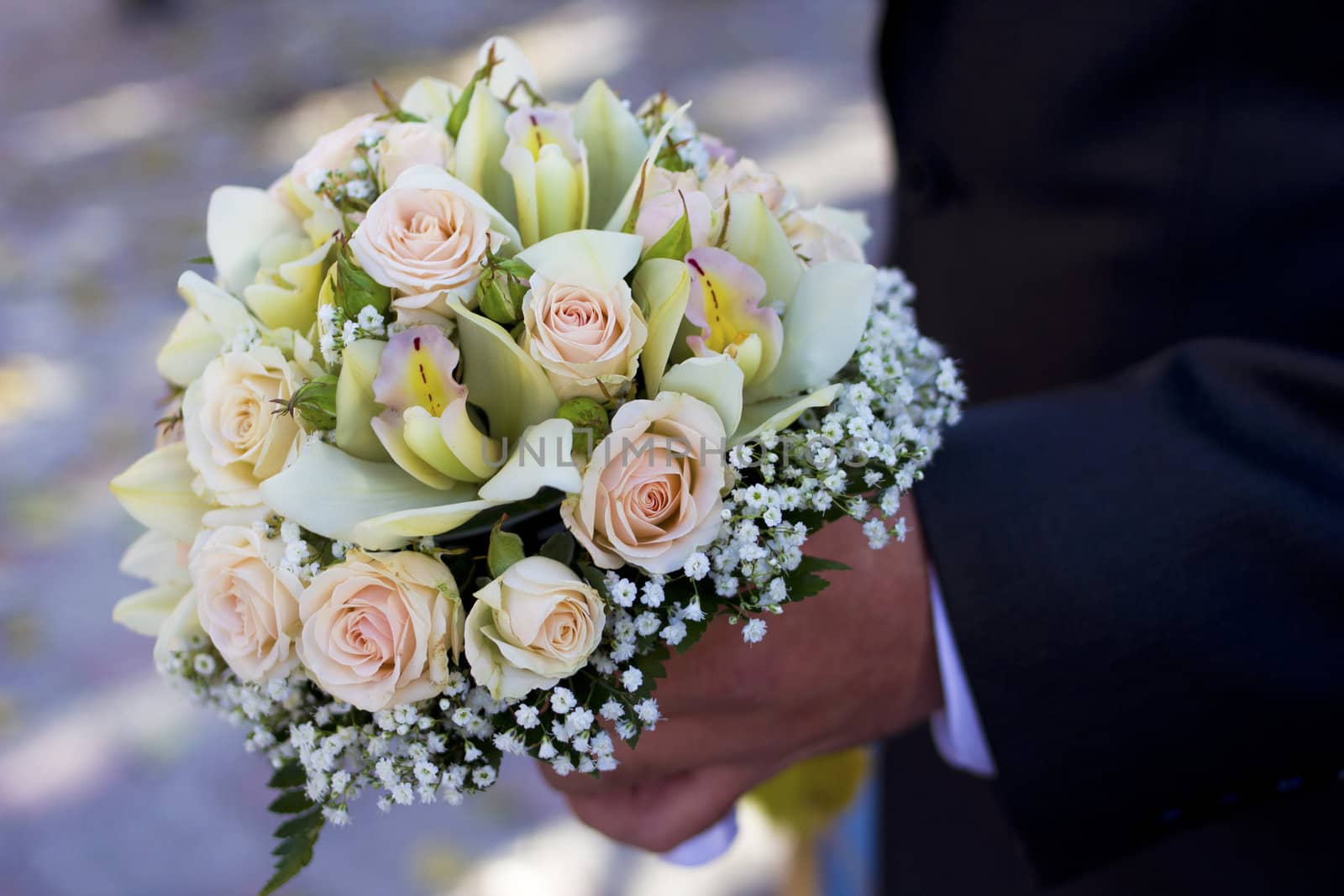 Man hold beautiful colorful wedding flowers in hand